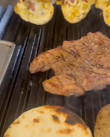 Carne y arepas asándose en la parrilla